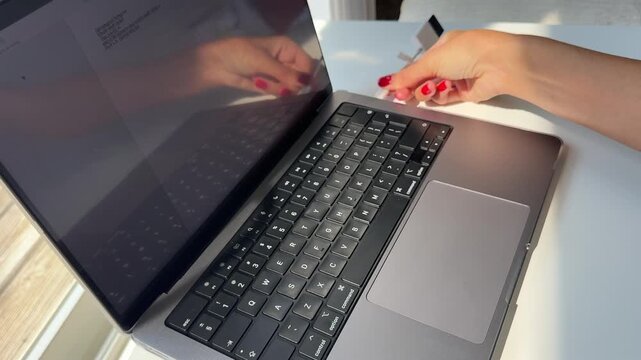 4K horizontal close-up video of a woman's hand with red manicure inserting a memory card adapter into a laptop. The scene represents digital data transfer, file management, technology, photography