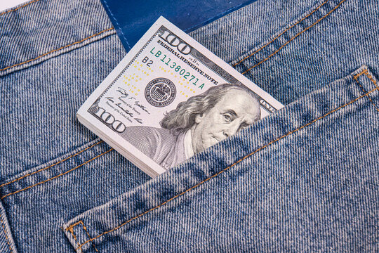 Stack of hundred dollar bills protruding from back pocket of blue denim jeans, simple composition, sharp contrast, casual setting, financial symbol, realistic texture, worn appearance