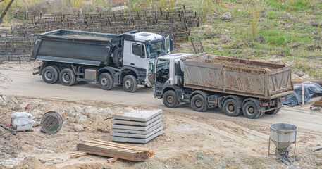 Construction Site with Dump Trucks and Materials © Mister