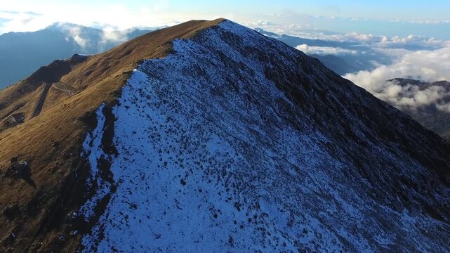 Aerial view of fresh snow covering a sharp mountain ridge in the Peruvian Andes at high altitude.