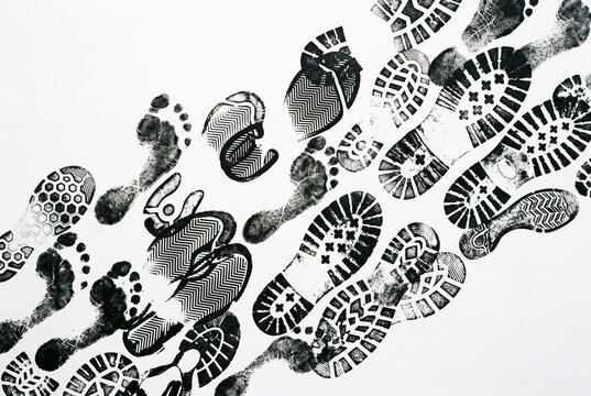 Multiple black shoe prints walking across white background