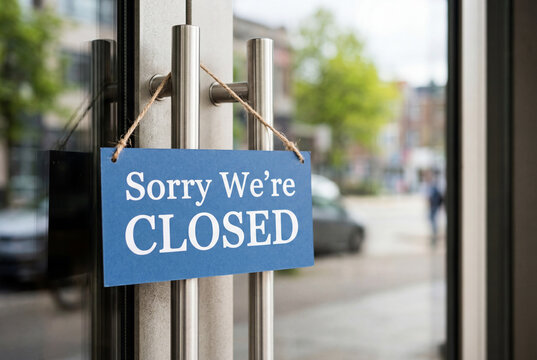 Blue closed sign hanging on a glass door of a local retail store or business