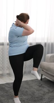 Overweight woman exercising on floor at home
