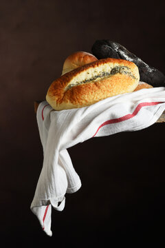 Artisan Bread Still Life. Three different styles of artisanal bread on a towel draped over a ledge with copy space.