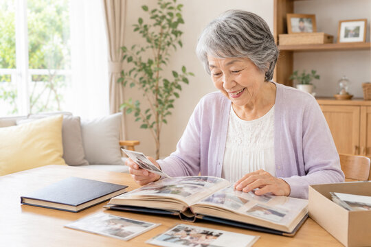 アルバムを見返して微笑むシニア女性