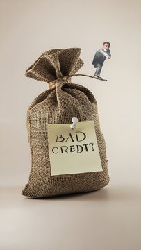 Piggy bank with bad credit label and coins spilling out.
