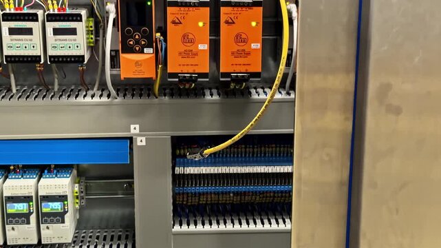 Close-up view of an electrical technician preparing cable terminals, showing hands working on electrical wiring and connectors during installation or maintenance
