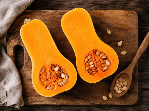 Fresh Butternut Squash Halves with Seeds on Wooden Cutting Board