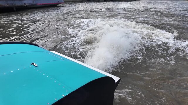 Stern of a powerful boat creating a strong wake while navigating on the water