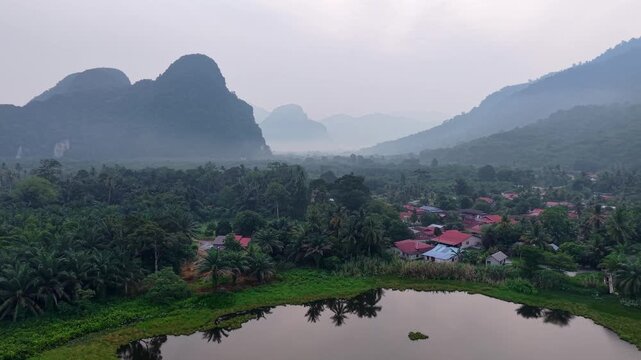 Misty limestone mountains overlook a tranquil lake at Kampar, Perak