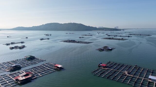 Aerial view of calm waters dotted with floating aquaculture structures at Pulau Aman, Penang