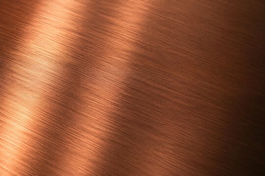 Brushed copper metal texture background with diagonal light gradient