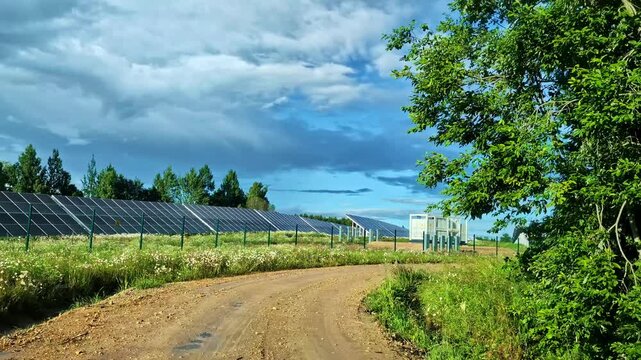 Personal perspective driving on a dirt road next to a solar panel power plant in the countryside
