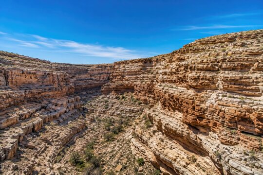 Deep desert canyon gorge landscape with layered rock cliffs
