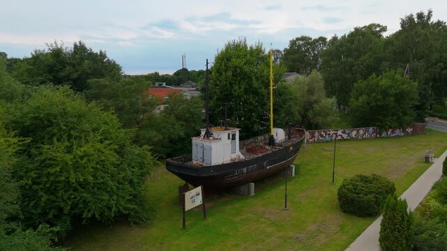 Aerial Drone View Of Pavilosta Town Center And The Saka River In Latvia. The Historic Ship Dole Rests Along The Waterfront, Surrounded By Charming Architecture And Beautiful Summer Scenery.