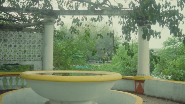 Yog Path in Panjim, India, features an open-air terrace with a circular planter, white columns, and lush greenery, offering a tranquil tropical setting for travel and architecture content.