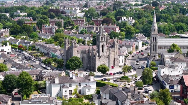 Beautiful Dun Laoghaire drone cityscape with Monkstown Church and seaside, sunny.