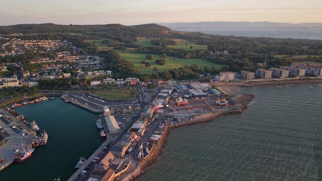 Aerial of Howth Shipyard and working harbour at golden evening light, Dublin, Ireland