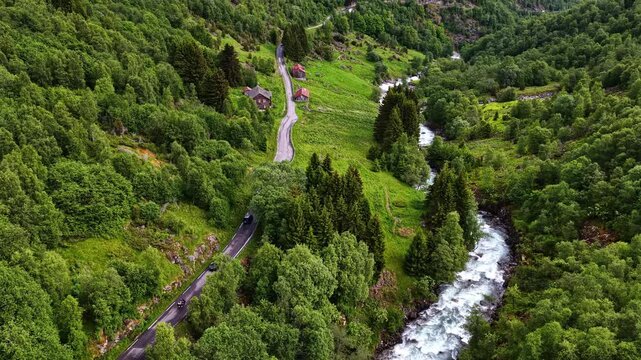 A Scenic Road Winds Through Lush Green Valleys, Flowing Rivers, and Peaceful Forests, Capturing the Breathtaking Countryside Journey From Fl&aring;m to Oslo, Norway - Drone Flying Forward
