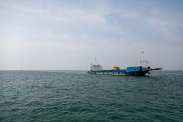 Naklejka premium Large ship sailing on the vast sea under a clear sky