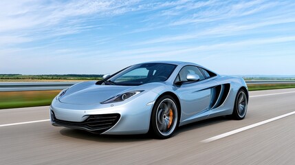 Fototapeta premium Sleek Silver Sports Car Racing on Open Road Against a Scenic Blue Sky with Fast Motion Blur and Dynamic Composition