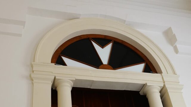 carved wooden fanlight window grand staircase grand master's palace valletta starburst pattern arched doorway stone columns malta historic government building baroque interior architecture detail
