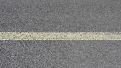 Close Up of Worn Yellow Center Line on Asphalt Road © LEJ