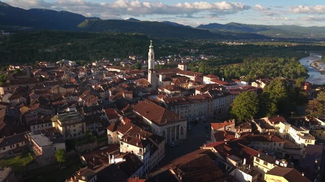 Historical city center showcases classic architecture with terracotta roofs and a prominent church tower rising above the dense urban landscape.