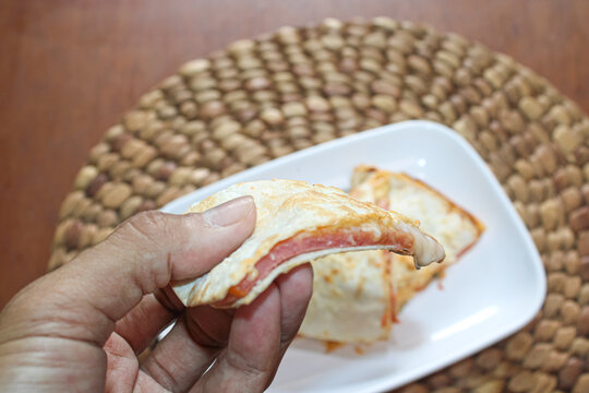 Person Holding Slice Of Cheesy Ham Quesadilla Sandwich Close Up