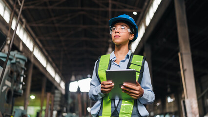 Engineer worker factory helmet tablet safety vest inspection industry woman engineer wearing helmet and safety vest holding tablet during factory inspection in industrial workplace © chokniti