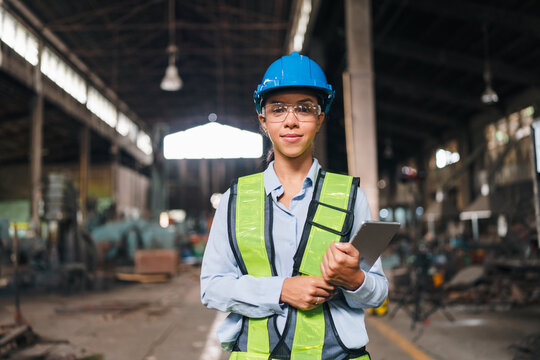 Engineer factory helmet safety vest clipboard worker industry woman portrait of confident female engineer with protective gear in industrial workshop