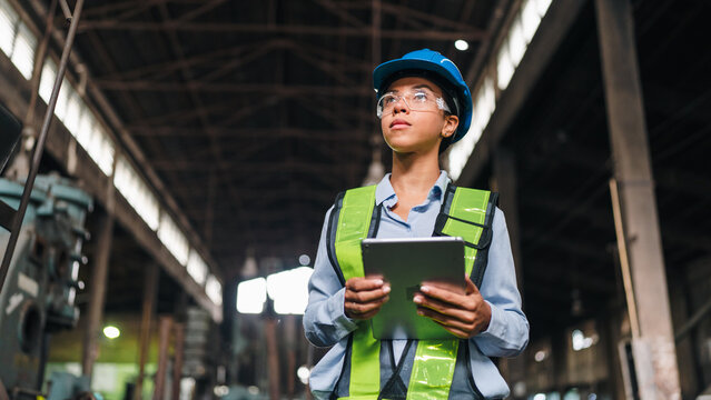 Engineer worker factory helmet tablet safety vest inspection industry woman engineer wearing helmet and safety vest holding tablet during factory inspection in industrial workplace
