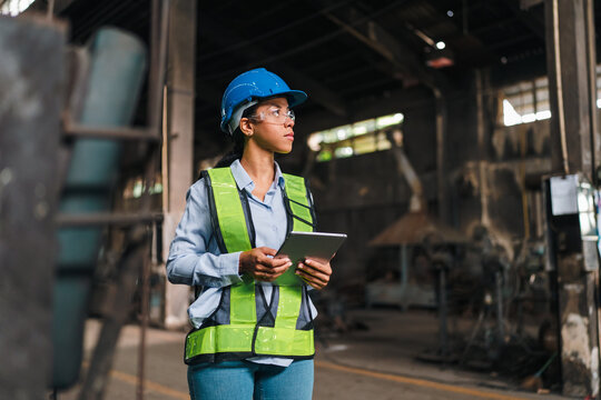 Engineer woman hard hat safety vest tablet factory industrial worker inspection warehouse, female engineer holding tablet factory with blue hard hat, safety vest, glasses, focused expression