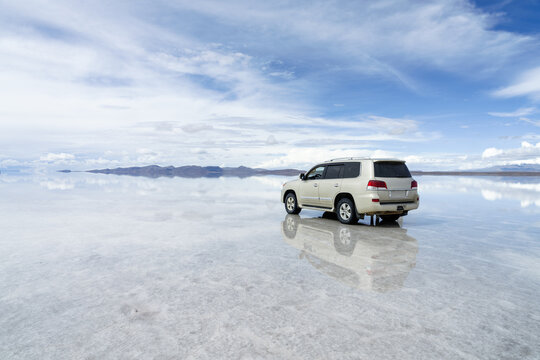 Silver 4x4 on the flooded Salar de Uyuni, Bolivia