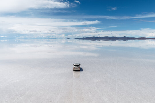 4x4 suv car on the horizon of the Salar de Uyuni, Bolivia