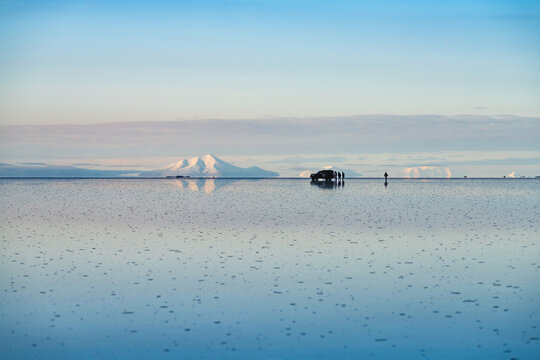 Snow-capped volcano mirrored on the Salar de Uyuni, Bolivia