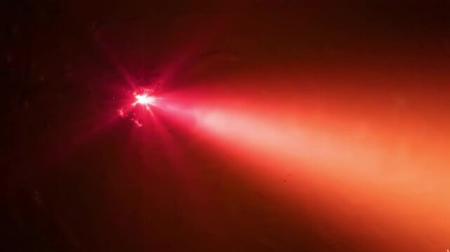 Bright red laser beam cutting through dark smoke or fog, creating a dramatic light effect with particles and intense glow