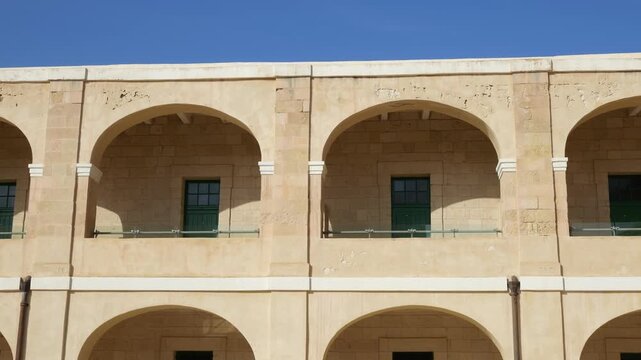 military barracks arcade fort st elmo two story limestone facade green shutter doors arched colonnade valletta malta coastal fortification historic architecture star fort military accommodation