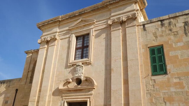 baroque entrance facade fort st elmo carved pediment window ionic pilasters coat of arms cartouche green shutter limestone valletta malta historic architecture star fort ceremonial entrance