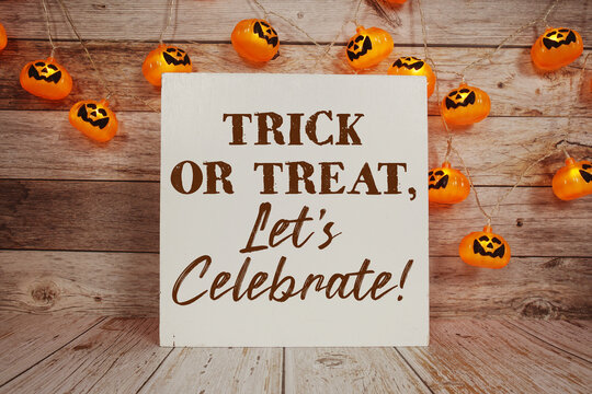 Trick or Treat Let's Celebrate! with Halloween decoration on wooden background