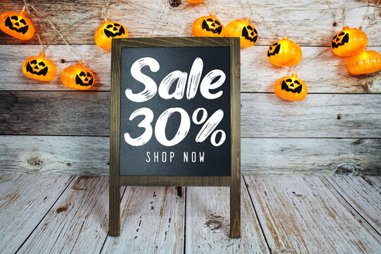 Halloween Sale 30% text with Halloween decoration on wooden background