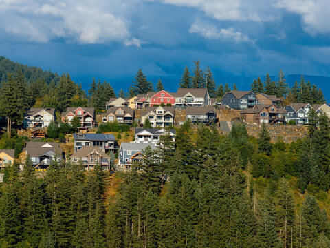 Colorful Hilltop Homes Overlooking Forested Valley With Dramatic Clouds in Harrison Mills, British Columbia, Canada