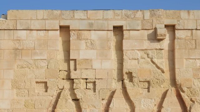 bastion wall machicolation detail fort st elmo carved stone corbels limestone masonry defensive wall clear blue sky valletta malta coastal fortification star fort defensive stonework architecture