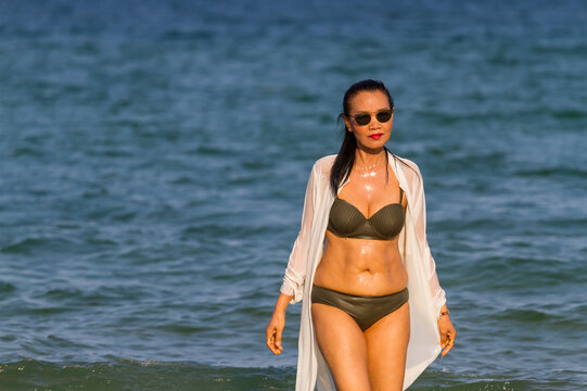 Woman with brown bikini walk on beach