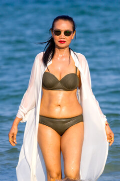 Woman with brown bikini walk on beach