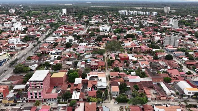 4K Aerial drone footage flying over a dense residential area towards the city.