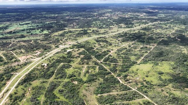 Vista a&eacute;rea de dron en movimiento lento sobre paisaje rural con campos verdes y bosques