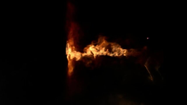 Intense orange flames burning against a dark background with video captures bright orange fire burning dynamically against pitch black background