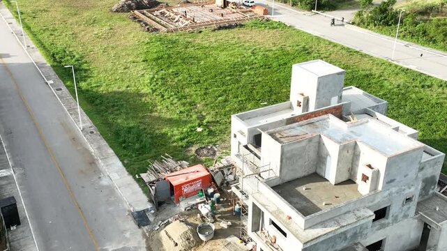 Aerial view of a construction site with workers building a modern house using pre-cast concrete structures in Florianopolis, Santa Catarina, Brazil.