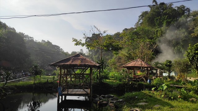 Traditional Bamboo Gazebos by a Peaceful Tropical Pond in a Morning Jungle